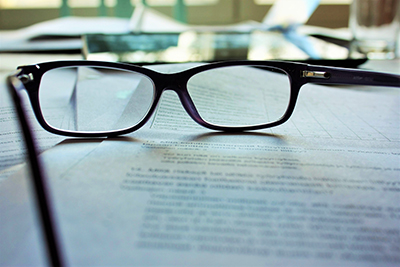 image of glasses sitting on a stack of papers