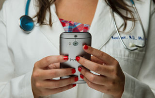 female doctor holding cell phone