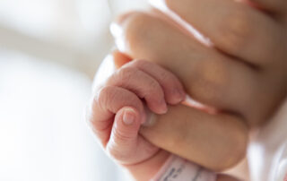 Baby and mom holding hands